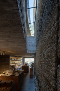 Casa ristrutturata e trasformata in libreria con cemento e acciaio di TAO Architects