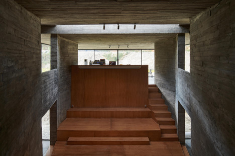 Casa ristrutturata e trasformata in libreria con cemento e acciaio di TAO Architects